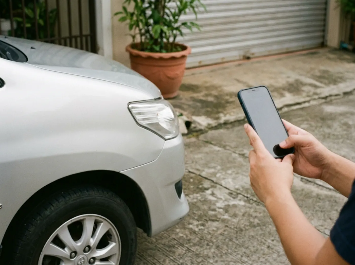 Staff photographing the front corner of a silver Innova at pickup